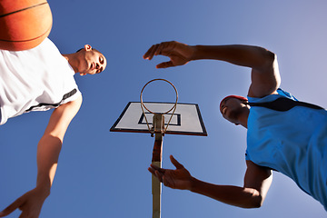 Image showing Men, player and basketball match at outdoor court or low angle of challenge team, dunk on rival. Male people, hoop and score point in summer park at fitness game or competition, athlete on blue sky