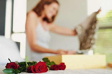 Image showing Woman, roses and box with gift in bedroom on birthday, celebration and valentines day event in home. Girl, dress and fashion with bouquet, flowers and floral present with thinking on bed in house