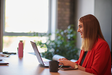 Image showing In a contemporary office setting, a young businesswoman is focused on her laptop, displaying dedication and efficiency in her work