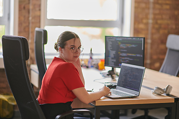 Image showing In a contemporary office setting, a young businesswoman is focused on her laptop, displaying dedication and efficiency in her work