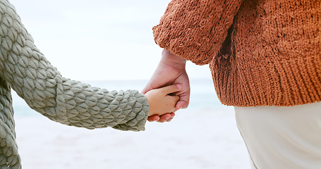 Image showing Parent, child and holding hands at ocean for love, care or support in trust, travel or outdoor getaway. Closeup of person with kid for unity, bonding or compassion on beach or sea coast together