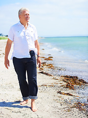 Image showing Beach, walking and elderly man on a travel tropical vacation, holiday or weekend trip in summer. Adventure, outdoor and senior male person in retirement on the sand by the ocean or sea on getaway.