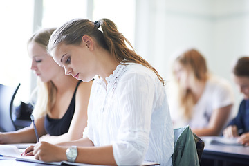 Image showing College student, writing and learning with notes in class, lecture or people in education. University, classroom and exam or test on campus with knowledge or studying a course in academy or school