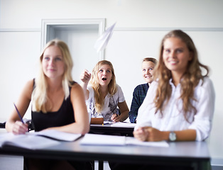 Image showing Paper, plane and students in class at school with fun, joke or people in education. Teenagers, classroom and learning at academy campus with funny friends, surprise and throwing prank airplane