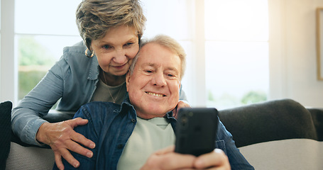 Image showing Senior, couple and hug with phone or happy for social media, streaming or internet scroll on sofa of living room. Elderly, woman and man with smartphone on couch in lounge for digital app and smile