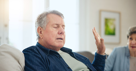 Image showing Senior, couple or stress with conflict and fight on sofa in living room of home with hand for stop. Elderly, man or woman with argument, upset and frustrated on couch in lounge of house or ignore