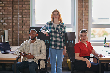 Image showing A diverse group of young business individuals congregates in a modern startup coworking center, embodying collaborative innovation and a dynamic atmosphere.