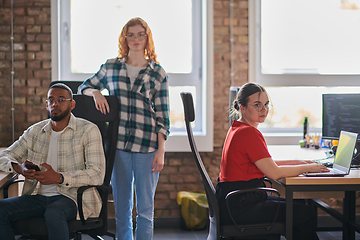 Image showing A diverse group of young business individuals congregates in a modern startup coworking center, embodying collaborative innovation and a dynamic atmosphere.