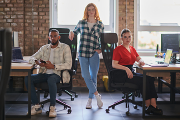 Image showing A diverse group of young business individuals congregates in a modern startup coworking center, embodying collaborative innovation and a dynamic atmosphere.