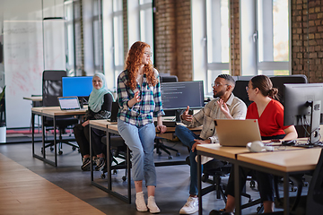 Image showing A diverse group of young business individuals congregates in a modern startup coworking center, embodying collaborative innovation and a dynamic atmosphere.