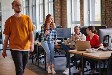 Image showing A diverse group of young business individuals congregates in a modern startup coworking center, embodying collaborative innovation and a dynamic atmosphere.