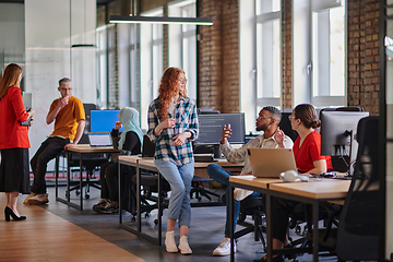 Image showing A diverse group of young business individuals congregates in a modern startup coworking center, embodying collaborative innovation and a dynamic atmosphere.