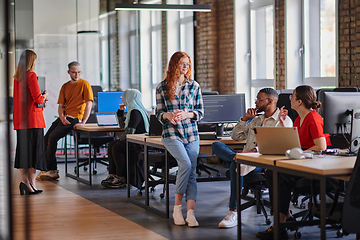 Image showing A diverse group of young business individuals congregates in a modern startup coworking center, embodying collaborative innovation and a dynamic atmosphere.