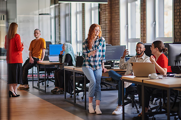 Image showing A diverse group of young business individuals congregates in a modern startup coworking center, embodying collaborative innovation and a dynamic atmosphere.