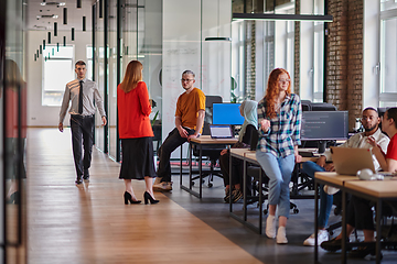 Image showing A diverse group of young business individuals congregates in a modern startup coworking center, embodying collaborative innovation and a dynamic atmosphere.