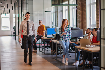 Image showing A diverse group of young business individuals congregates in a modern startup coworking center, embodying collaborative innovation and a dynamic atmosphere.