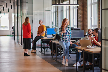 Image showing A diverse group of young business individuals congregates in a modern startup coworking center, embodying collaborative innovation and a dynamic atmosphere.