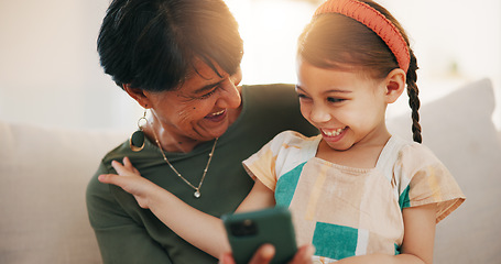 Image showing Child, grandmother and cellphone laugh on sofa or online connection, games or bonding. Kid, old woman and smile for social media or funny joke embrace on couch together relax, love or trust safety