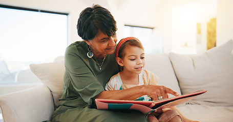 Image showing Grandmother, child and reading book on sofa for literature, education or bonding together at home. Grandparent with little girl or kid smile for story, learning or relax on living room couch at house