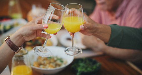 Image showing Lunch. closeup and people with juice, cheers and dining room with fruit beverage, relax and wellness. Family, home and hands drink with health, nutrition meal and toast with celebrate and relaxing