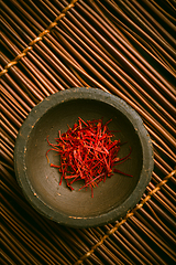 Image showing Saffron threads in a small bowl. Spices, cooking ingredients, flavor.