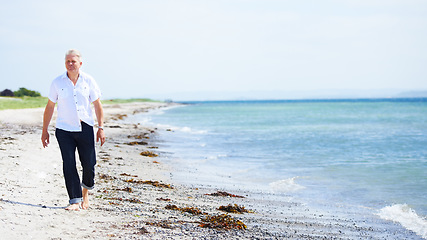 Image showing Beach, walking and senior man on a travel tropical vacation, holiday or weekend trip in summer. Adventure, outdoor and elderly male person in retirement on the sand by the ocean or sea on getaway.