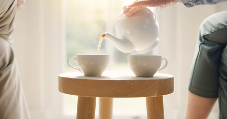 Image showing Pour, pot and hands with tea cup in morning, home and closeup on drink, steam and table. Hot, beverage and person with hospitality, service and drinking in the afternoon with guest in living room