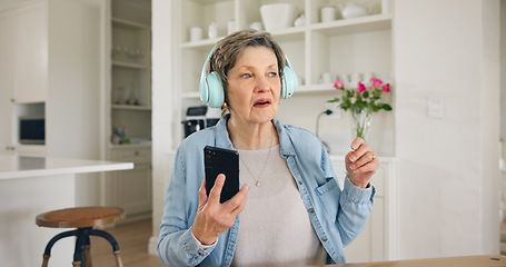 Image showing Music, headphones and senior woman with phone in a kitchen for streaming, album or track at home. Smartphone, app and elderly lady person with earphones for online audio, radio or podcast in a house