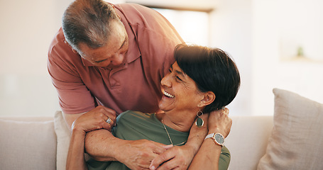 Image showing Mature, man and woman with smile for embrace in living room on sofa for love, care or romance in relationship. Happy couple, together or married in laugh by funny joke, memory or conversation in home