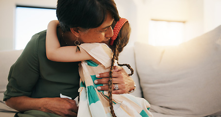 Image showing Family, love and girl hugging her grandmother on a sofa in the living room of their home during a visit together. Trust, care and security with a senior woman embracing her grandchild in an apartment