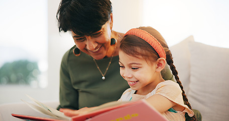 Image showing Grandparent, kid and reading book with smile, home and child development, grandchild and couch. Woman, lounge or bonding together for relationship, family and retired with girl, house and happy