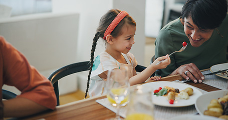 Image showing Food, family and a girl feeding her grandmother at a dining room table while in their home for a visit together. Love, smile and a senior woman eating a meal with her happy grandchild in an apartment