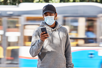 Image showing Man in city with mask, phone and travel in morning at bus stop, checking service schedule or social media. Public transport safety in covid, urban commute and person in street with smartphone app.