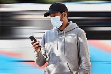 Image showing Man in city with mask, phone and waiting at bus stop to travel, checking service schedule or social media. Public transport safety in covid, urban commute and person in street with smartphone app