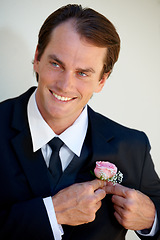 Image showing Groom man, boutonniere and hands on suit for style with pride, smile and ready for wedding, party or celebration. Man, flowers or rose on tuxedo with thinking, preparation or happy for marriage event