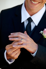 Image showing Hands, groom man and ring for wedding, celebration and commitment to relationship, smile and pride. Person, metal jewelry and tuxedo suit for marriage, happy and closeup at event, party or reception