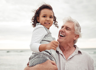 Image showing Beach, happy and elderly man with his grandchild on a family vacation during spring time. Travel, happiness and retired grandfather holding a girl child in nature by the sea while on holiday.