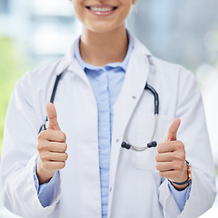 Image showing Healthcare, woman and thumbs up from doctor with a smile and blurred background. Success, thank you or approval from happy medical worker in hospital, cropped. Winner in medicine and yes to vaccine.