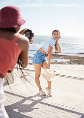 Image showing Beach, model and photo shoot with a woman outdoor on the promenade for a photograph with the sea, ocean or beautiful beach view. Fashion, photographer and summer with an attractive young female