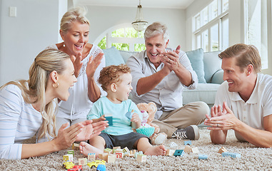 Image showing Family, clapping hands and baby playing with toys while sitting on the living room floor. Love, care and happy people cheering for child development, learning and growth while bonding in the lounge.