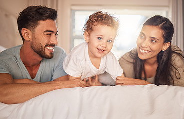 Image showing Happy, love and parents with their baby on bed in the bedroom bonding, playing and relaxing at home. Happiness, smile and couple laying with their child in hotel room while on family holiday together