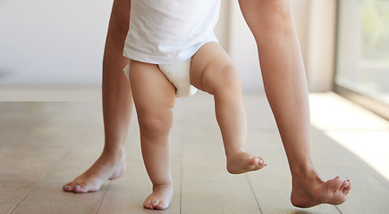 Image showing Baby, learning and walking with a child taking its first steps with his mother to learn to walk at home. Feet, legs and balance with a kid stepping forward for growth and development in the house