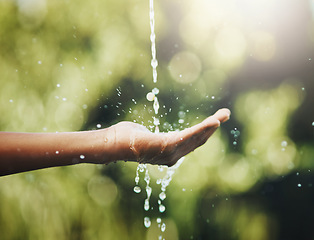 Image showing Hygiene, washing and saving water with hands against a green nature background. Closeup of one person holding out their palm to save, conserve and refresh with water in a park, garden or backyard