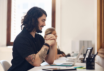 Image showing Young, happy and trendy businessman working on his laptop in an office. Male on an online business meeting talking about his startup. Professional guy sitting at a desk using voice assistant on call