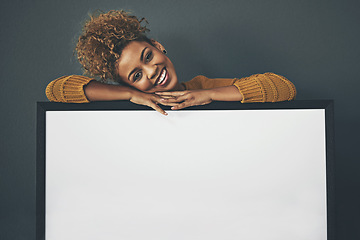 Image showing Woman standing with blank sign or portrait frame, showing copy space for advertising or marketing on dark background. Happy, smiling and relaxed Afro female portrait with big white poster copyspace