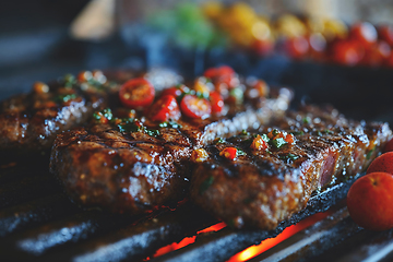 Image showing Large juicy beef rib eye steak on a hot grill