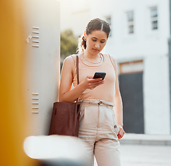 Image showing Traveling businesswoman with a phone texting, browsing internet while waiting outside for transport or replying to text while commuting to work. Young worker booking online transport service in city