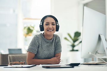 Image showing Relaxed, satisfied businesswoman listening to music in headphones while sitting alone in an office. Female office worker enjoying a podcast or songs during a break in a corporate company