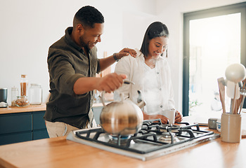 Image showing Loving couple having coffee or tea, relaxed and carefree while bonding in a kitchen at home. Caring husband being affectionate, talking and enjoying their relationship and quiet morning with his wife