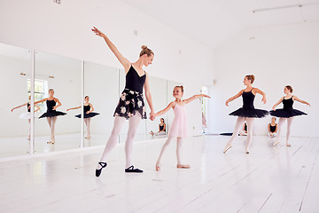 Image showing Ballet instructor or teacher teaching a young dancer in a class or dance studio preparing her for a performance. Young little girl learning to be a ballerina getting training for a coach